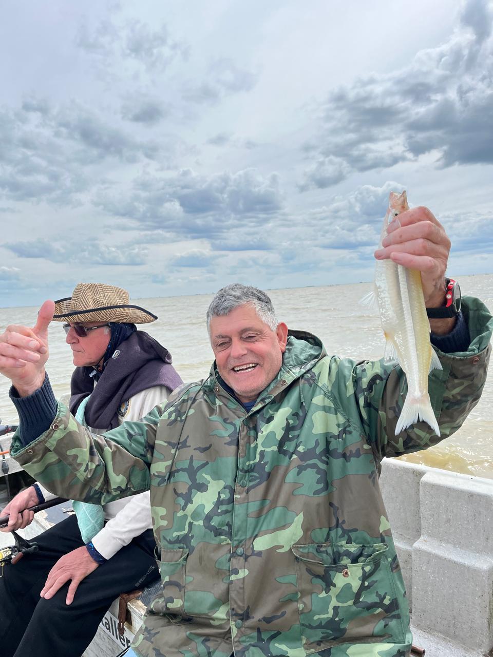 Pescador mostrando su captura en la laguna.